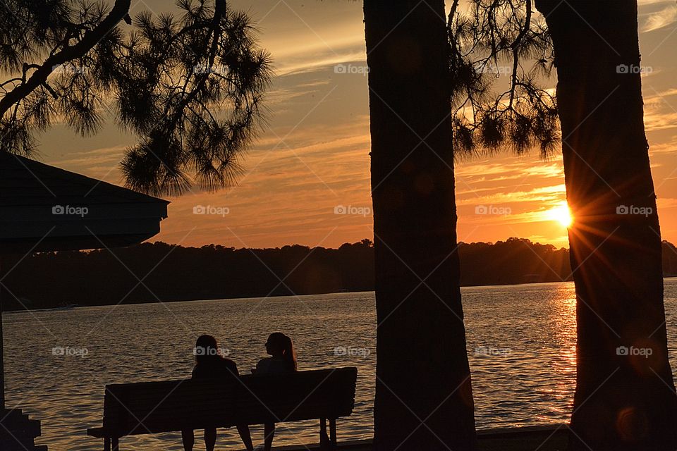 Friends setting together on a fall evening enjoying each other’s company and watching the spectacular sunset.