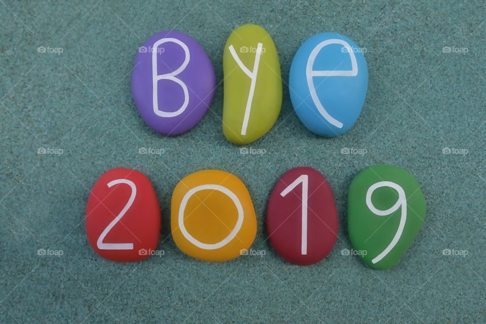 Bye 2019 celebrated with a colorful composition of painted stones over green sand