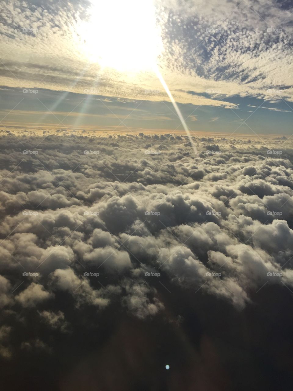 The sun above the clouds seen from the window of the airplane 