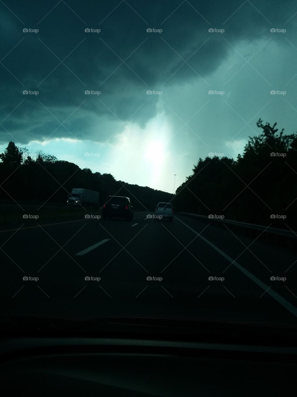 driving down the road.as the rain moves through the sun rays