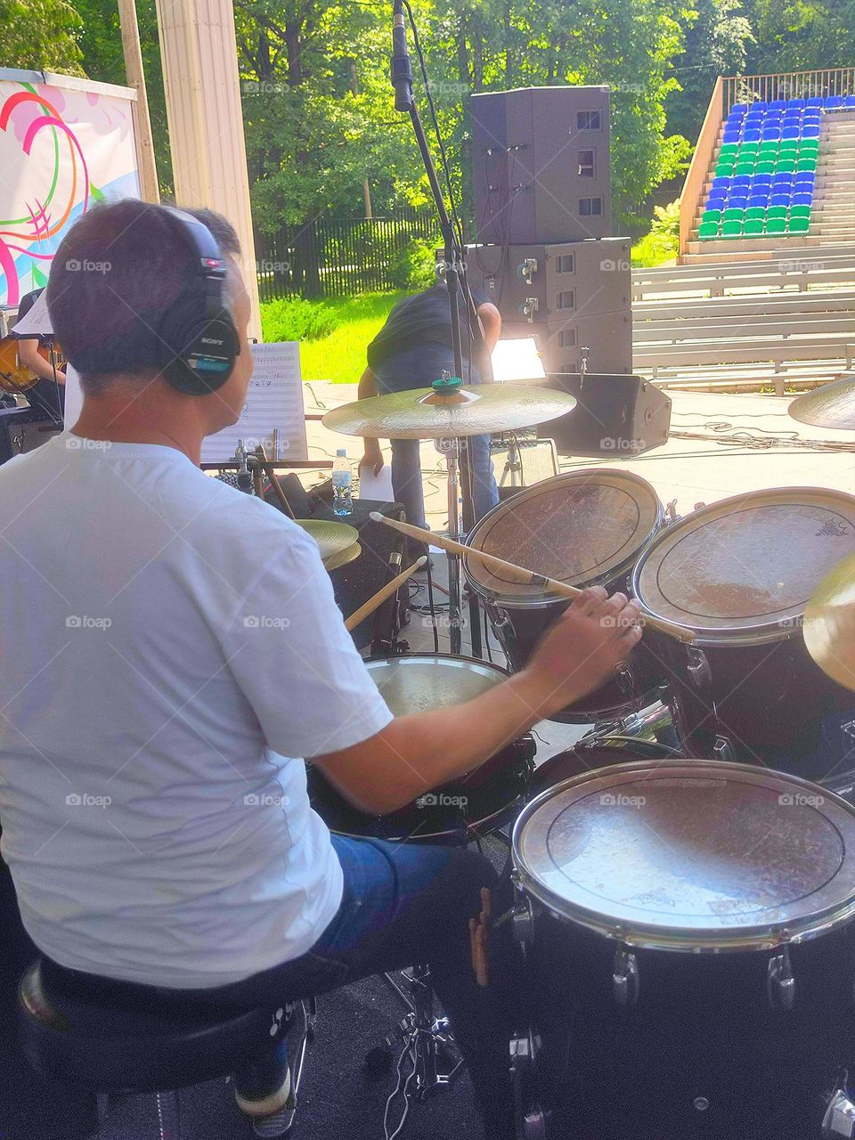 Summer day.  Instrument tuning before the concert.  Drummer checking percussion instruments