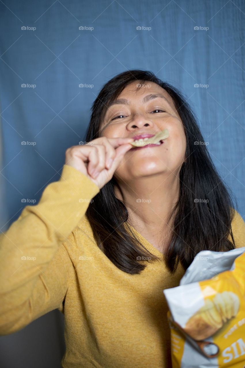 Portrait of a woman eating chips 