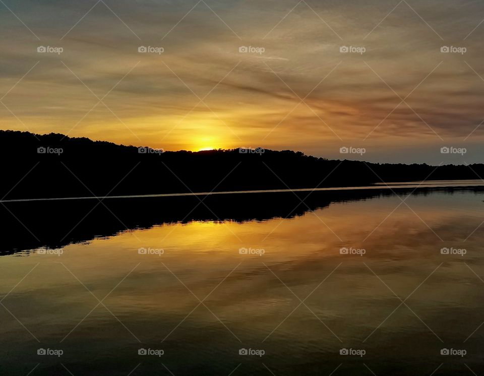 Golden rays as the sun sets on the lake.