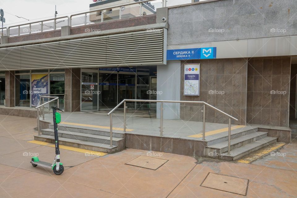 Electric scooter parked in front of the entrance of a metro station (in Sofia, Bulgaria)