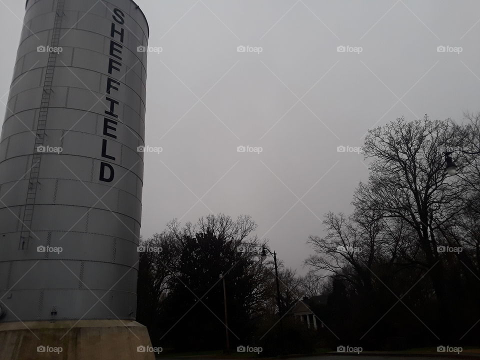 Very old but rugged water tower in Sheffield, Alabama on a grey foggy day
