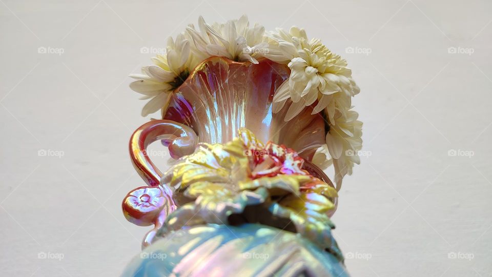 Beautiful white flowers in a colourful flowerpot with a flower sculpture, Flowers in a vase, colourful vase, white flowers in a vase