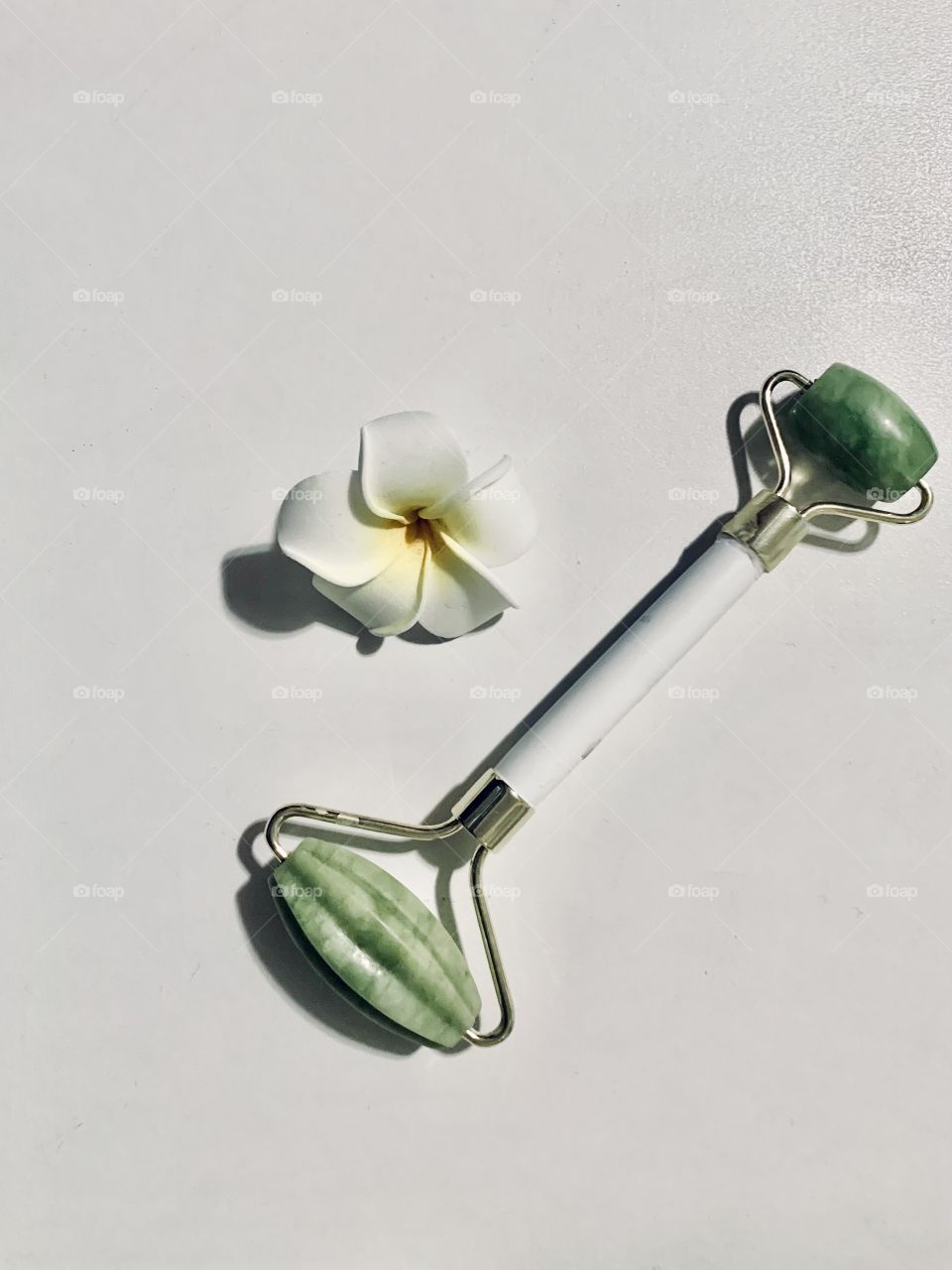 Jade roller and white flower - green and white colors 