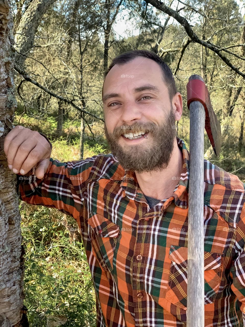 Portrait of Kevin smiling during a break from chopping wood