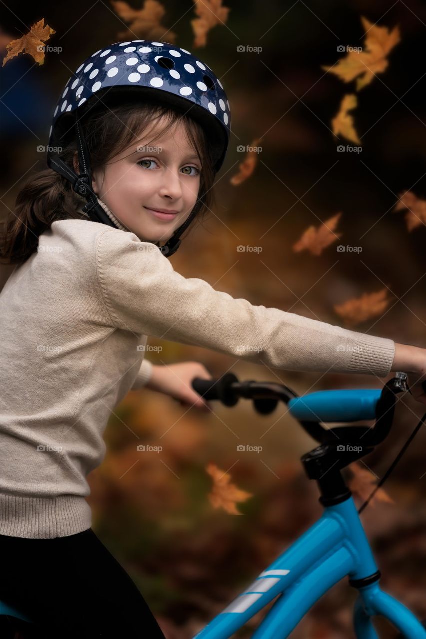 Kid riding bicycle with helmet.