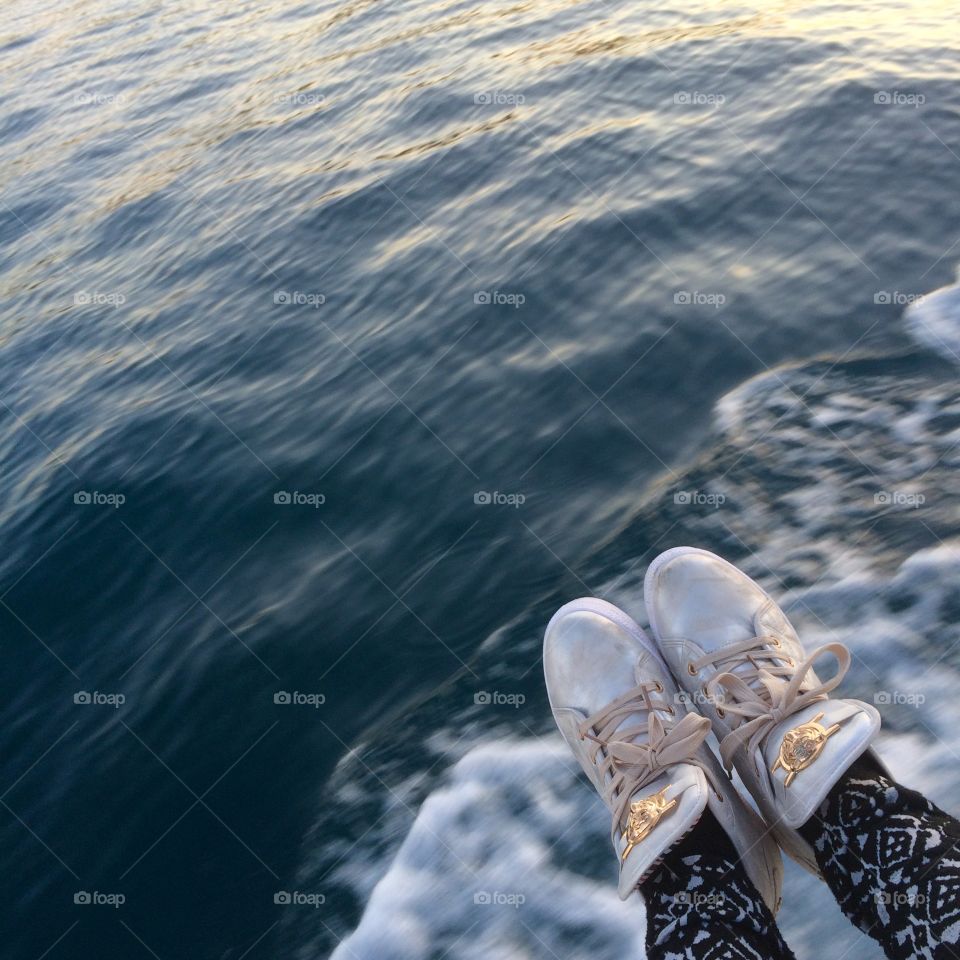 Feet pointing out of corner with sea water background 