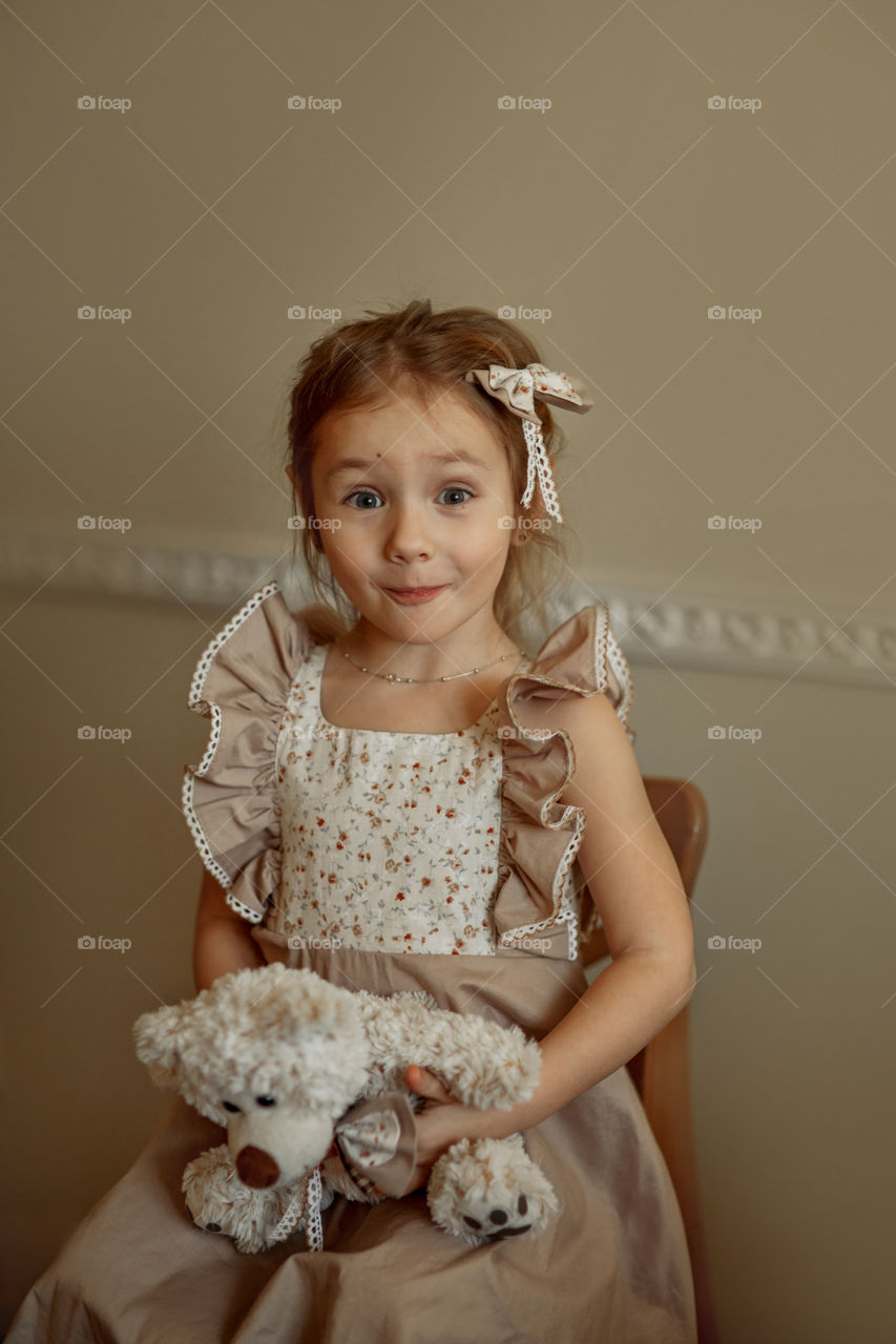 Vintage portrait of a beautiful little girl with teddy bear 