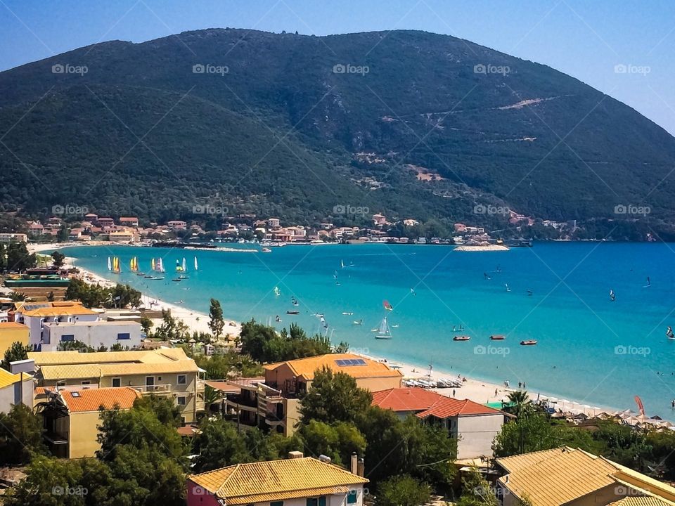 Background of Lefkada island with boats sailing on the turquoise Aegean Sea