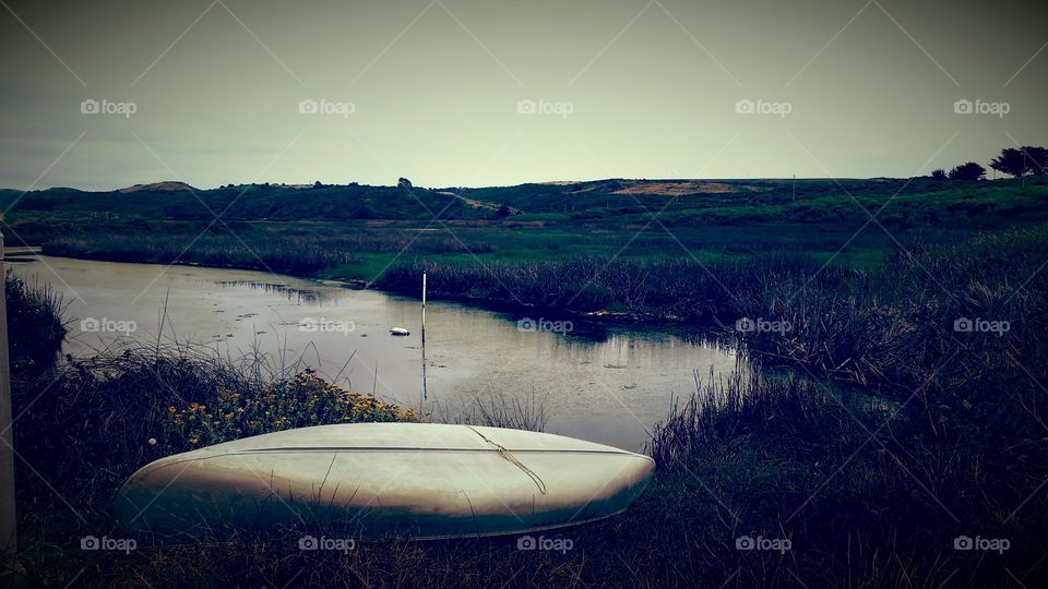 Upturned Canoe rowboat. Abandoned canoe in a marsh