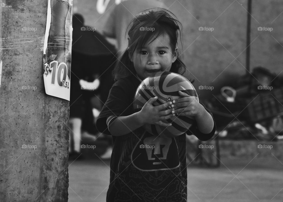 I took this photo while in a town in Mexico where I went as a volunteer to take food and supplies after the 2017 earthquake. I saw this little girl on the street playing ball with her sister and when she saw my camera, she sort of posed for me. 