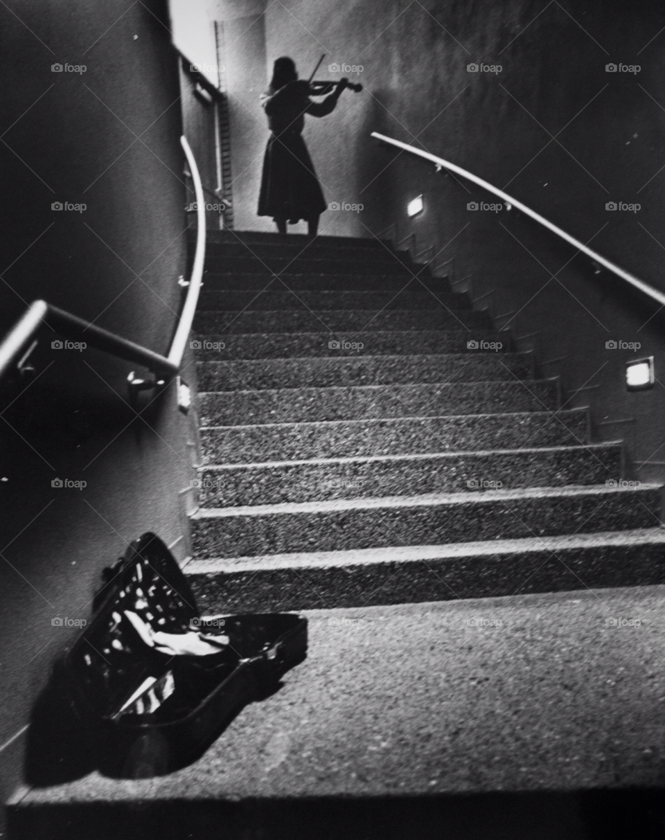 music student practices her violin skill in a stairway. arizona state university. music student. by arizphotog