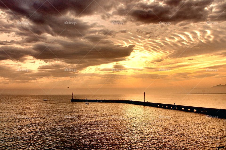 Silhouette of pier at beach during sunset