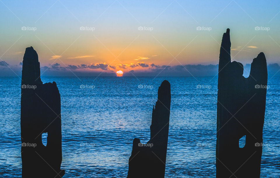 The sun rises over the English Channel on a cold December morning at Winchelsea Beach, U.K.