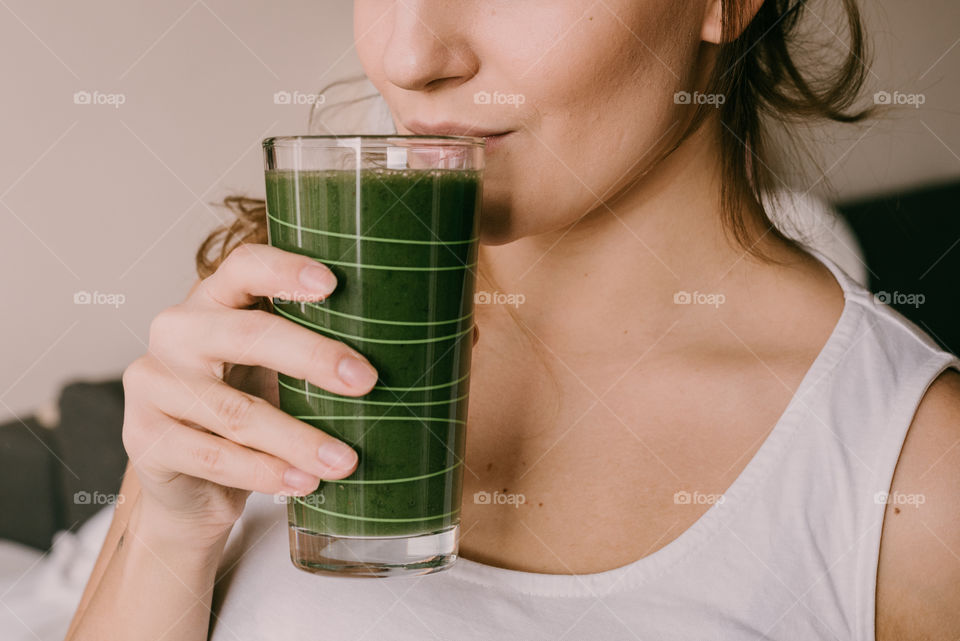 Young woman wearing white drinking smoothie