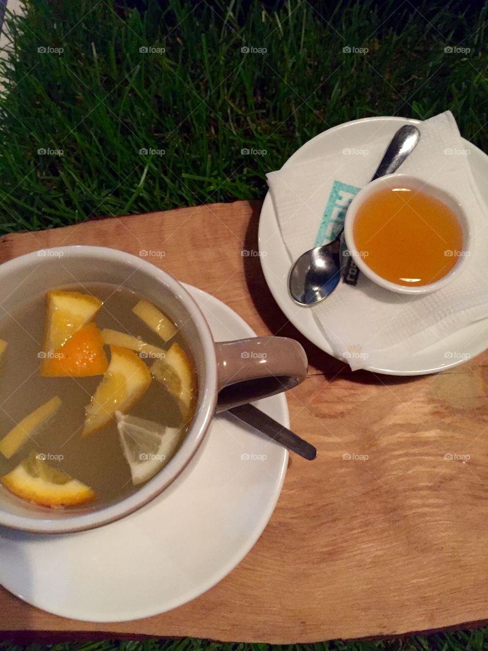 Ginger tea with honey on a wooden tablet on a table with grass