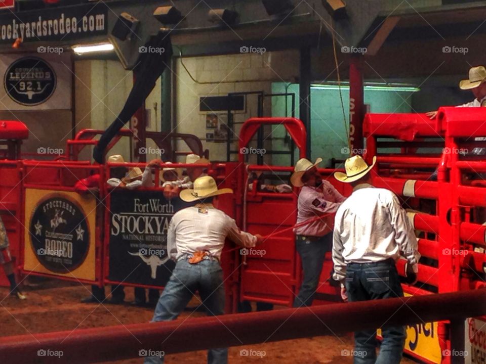 Ready, set, ride. Cowboys pulling gate open for a bull rider 