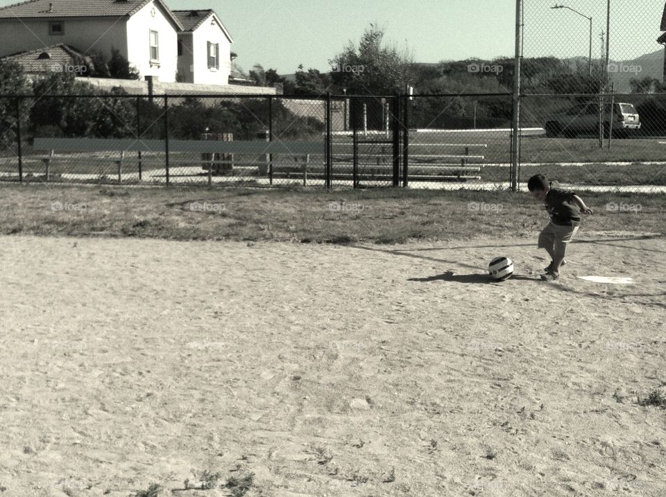 Playing ball. Boy playing kick ball