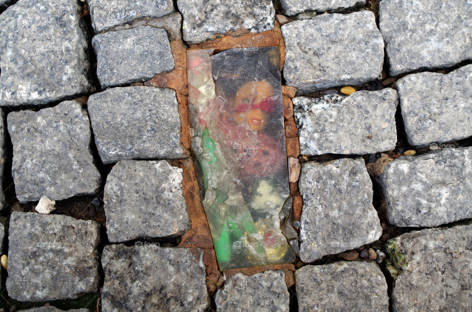 Close-up of doll between stone tiles in Berlin, Germany.