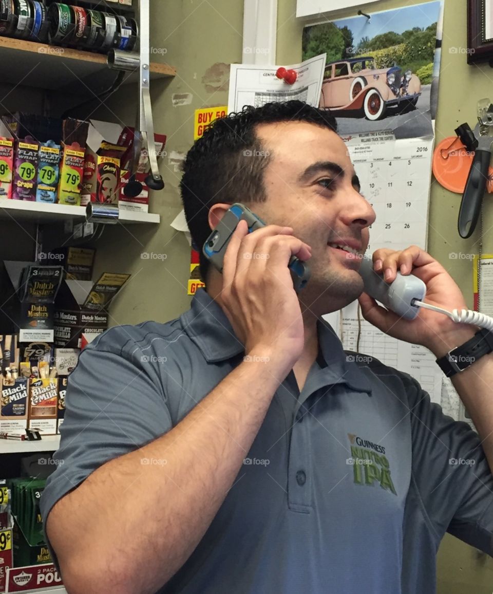 Working double time. A Charleston grocery store manager speaks with two different salesmen at the same time. 