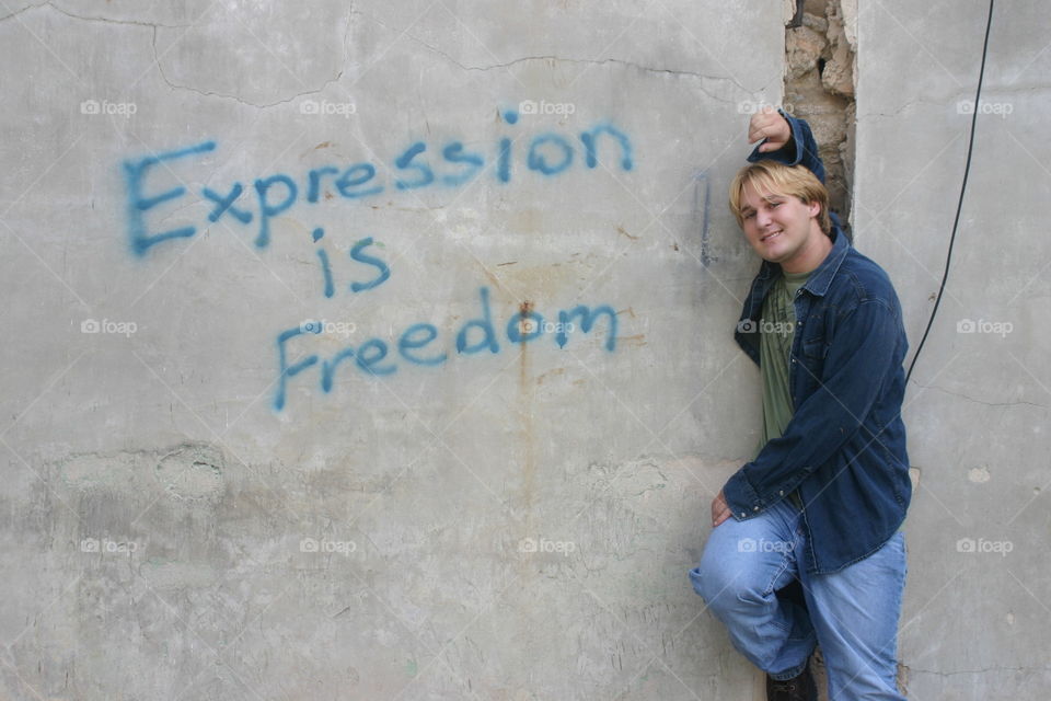 Man beside wall with freedom message