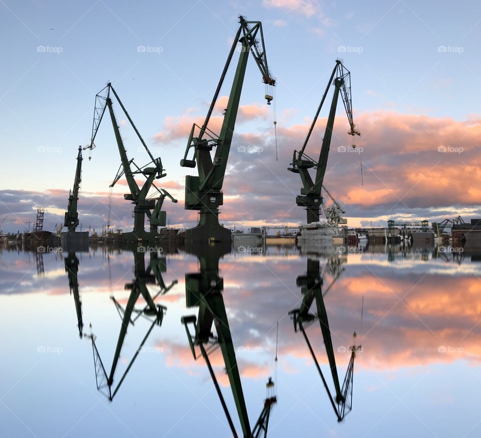 Cranes at harbour during sunset
