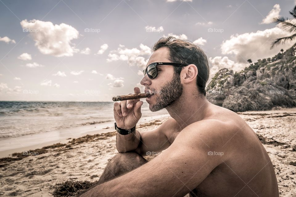 Young man smoking on beach