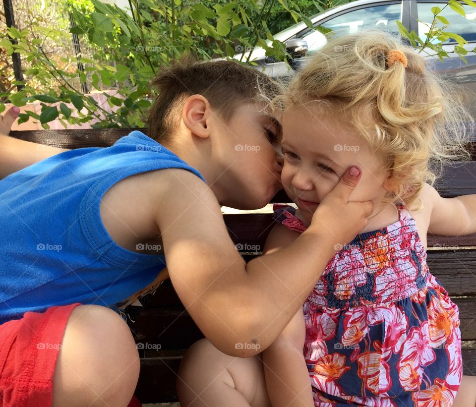 Little boy kissing girl on her cheek