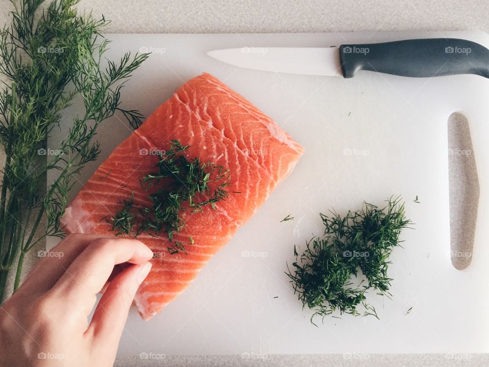 Close-up of a person preparing salmon food