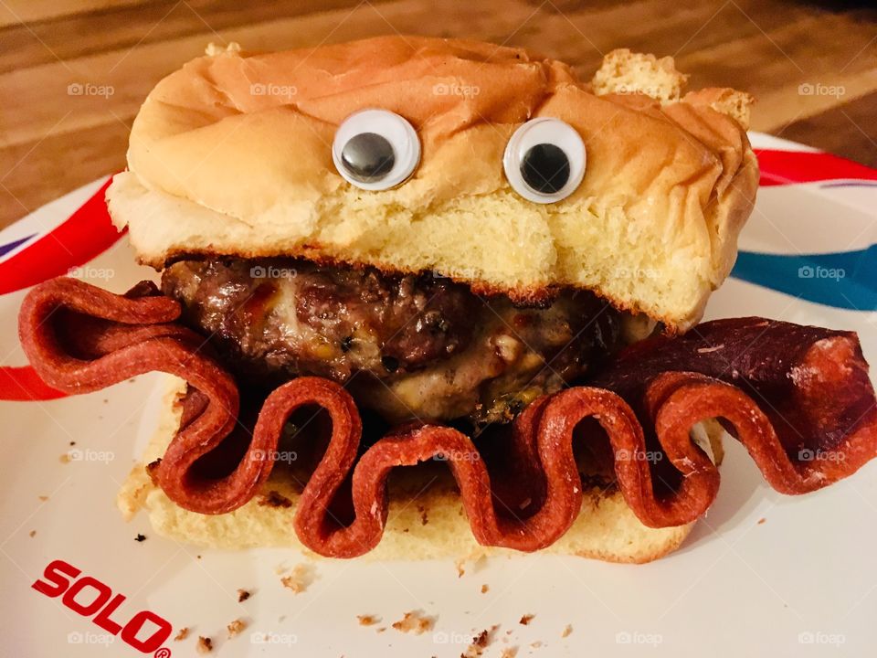 Fresh grilled hamburger with a google eye face