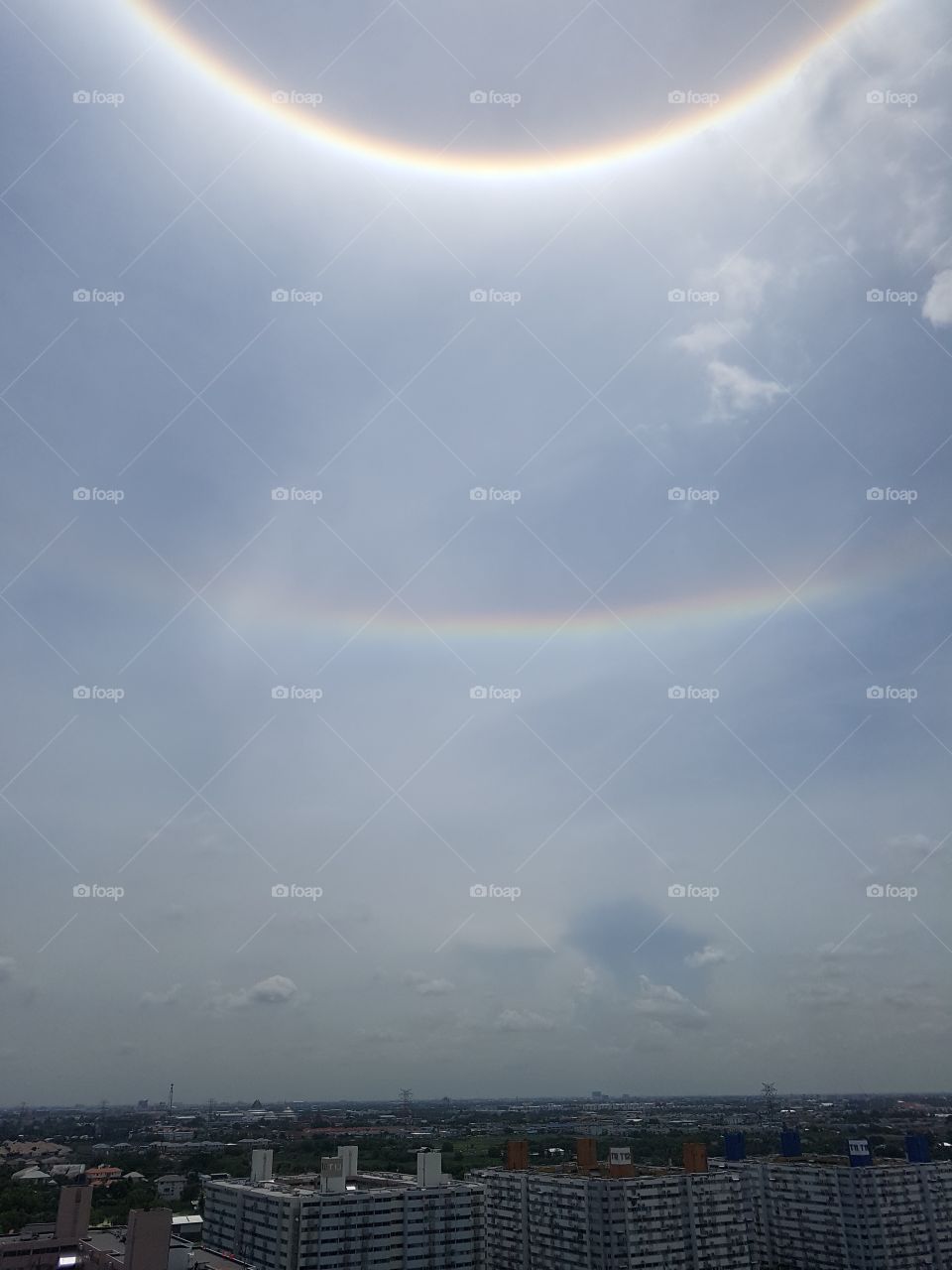 double circular rainbow light hallow above the city