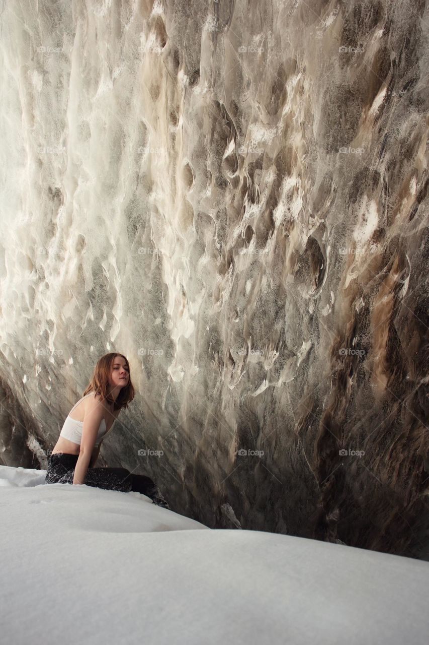 Girl in a top posing against an ice wall