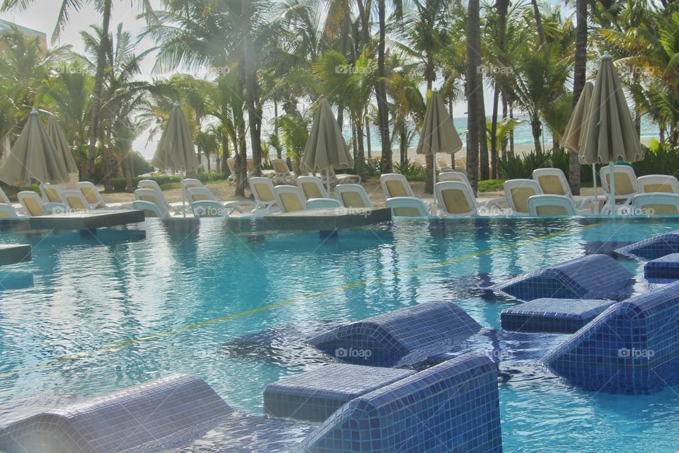 resort swiming pool with chairs underwater