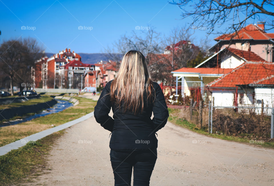 A blond woman observing houses and river