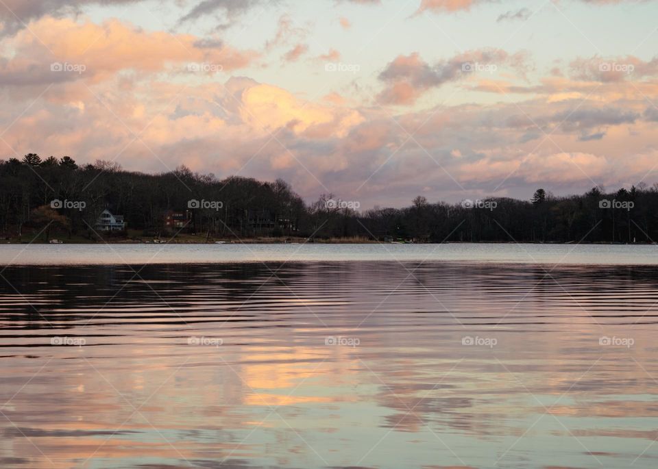 Rippled reflections of a Blushed cloudy sky over an expanses lake