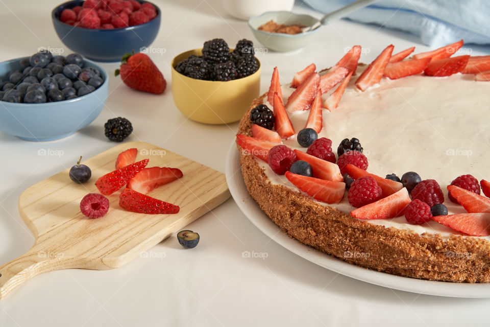 Decorating homemade cake with fresh fruit 