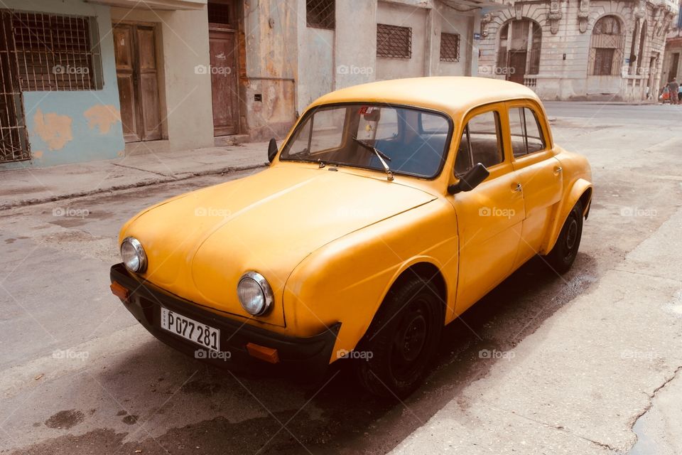 An old yellow car in the Street of Havanna Cuba