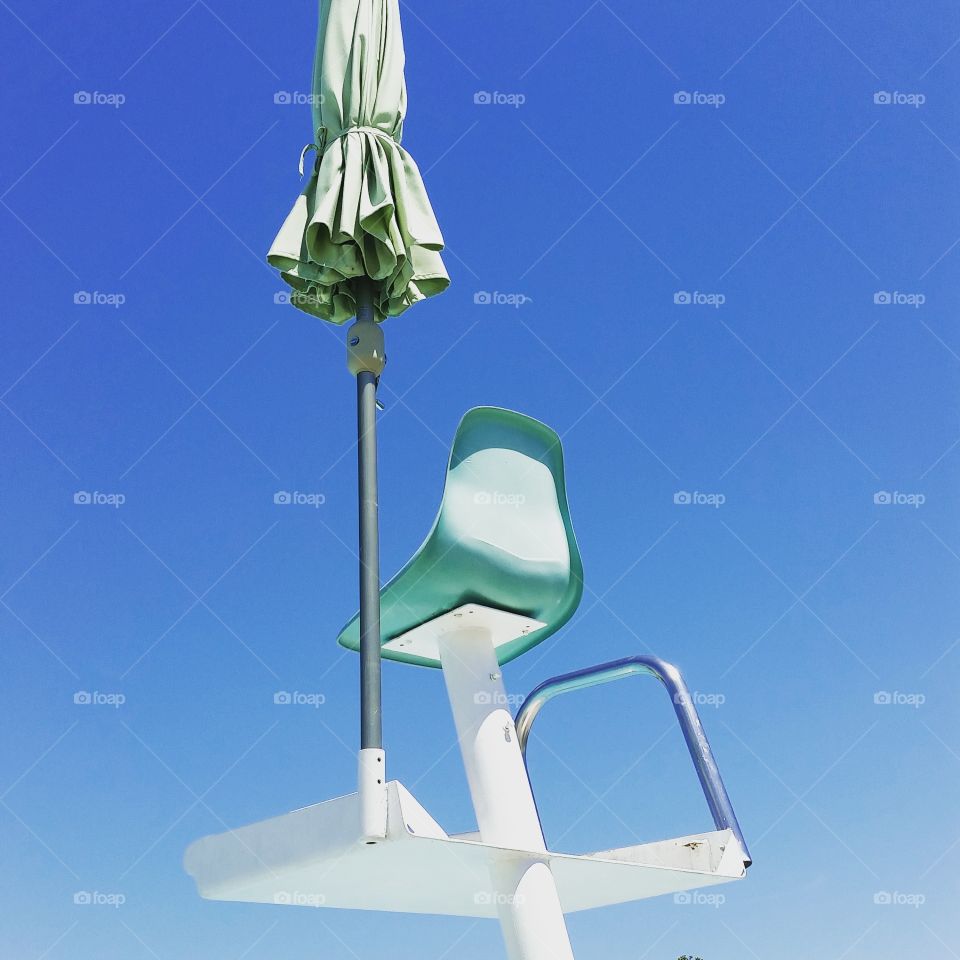 retro lifeguard seat elevated with umbrella by its side