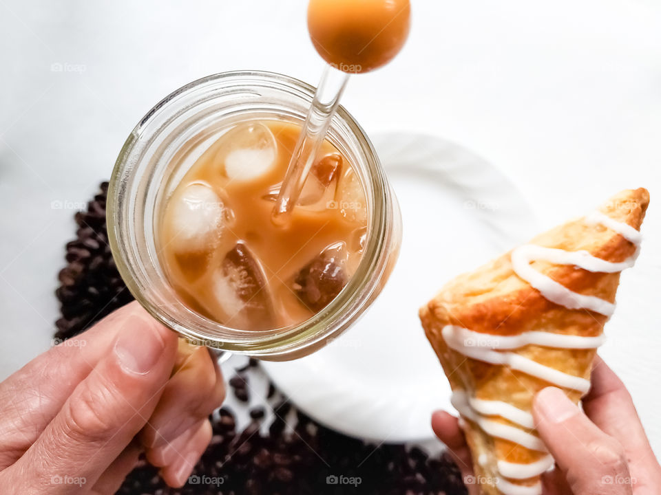 Iced coffee and a turnover pastry; a perfectly delicious pair .