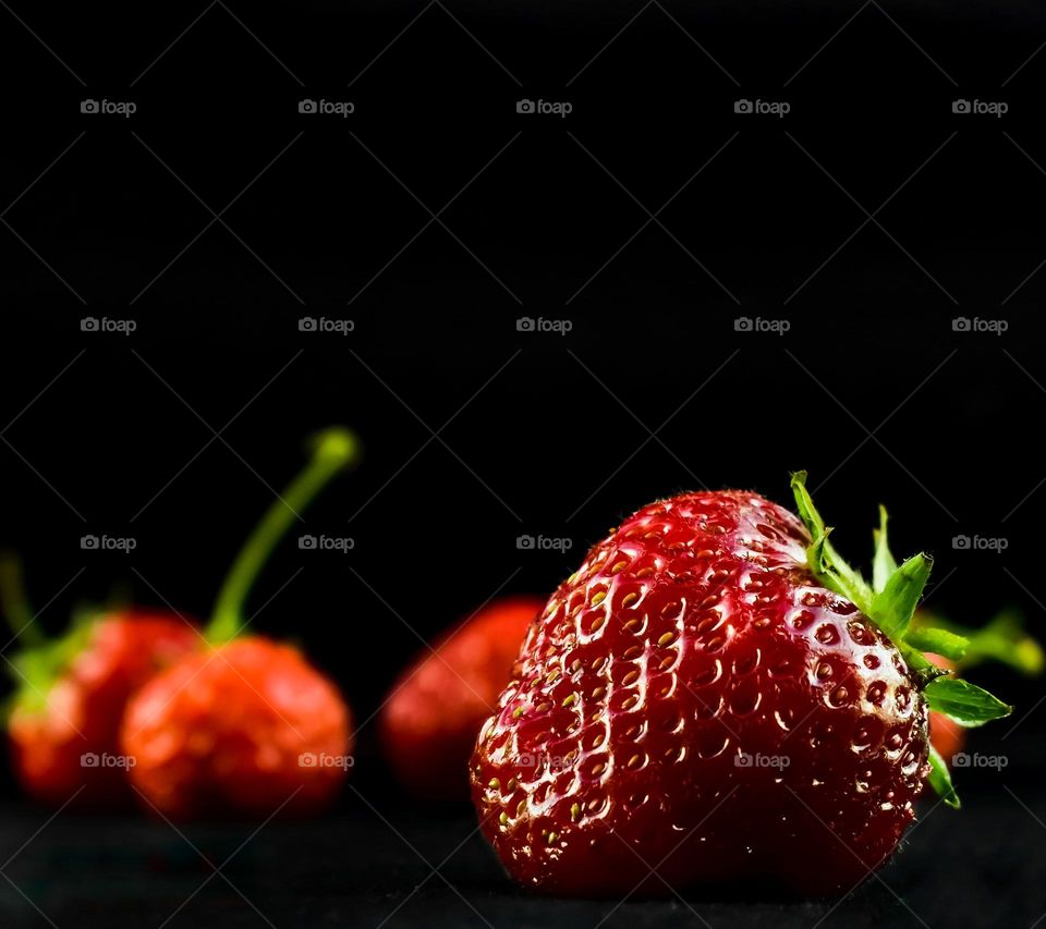 ripe red strawberries on a black background