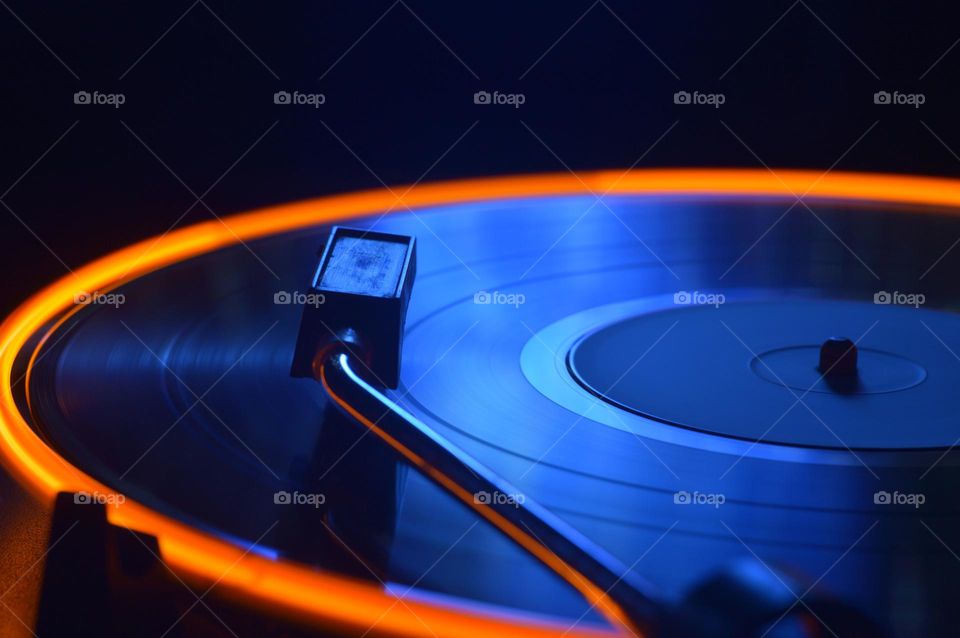 a vinyl record spins in the night and leaves a light neon trail radiance music album