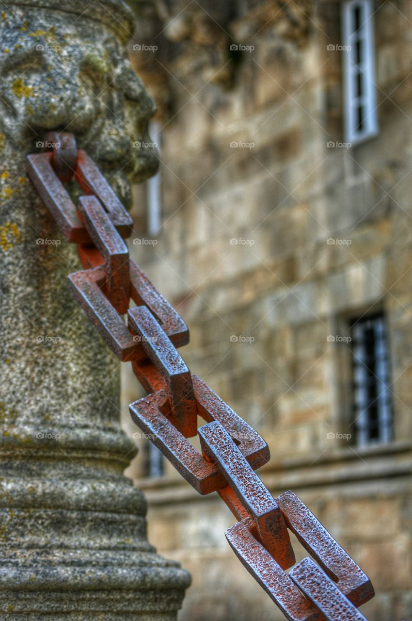 Old iron chain. Pillar and chain at the entrance to Hostal dos Reis Católicos, the oldest hotel in the world, Santiago de Compostela