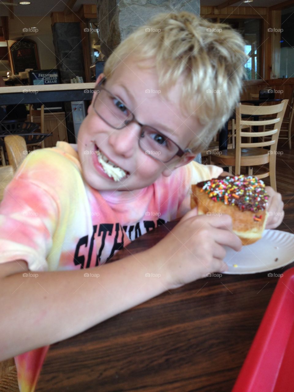 Happy boy eating doughnuts 