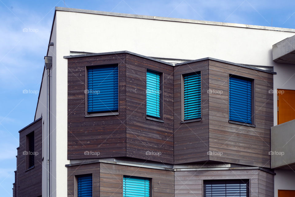 Low angle view of building with blue shutters against sky.