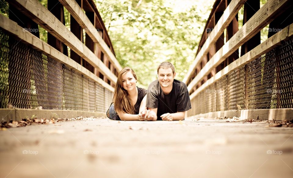 Couple lying on bridge