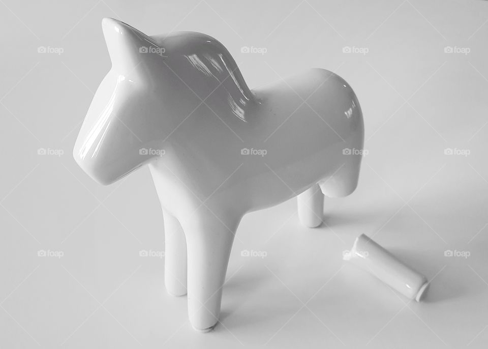 All-white porcelain Dala horse with broken leg (view from above)