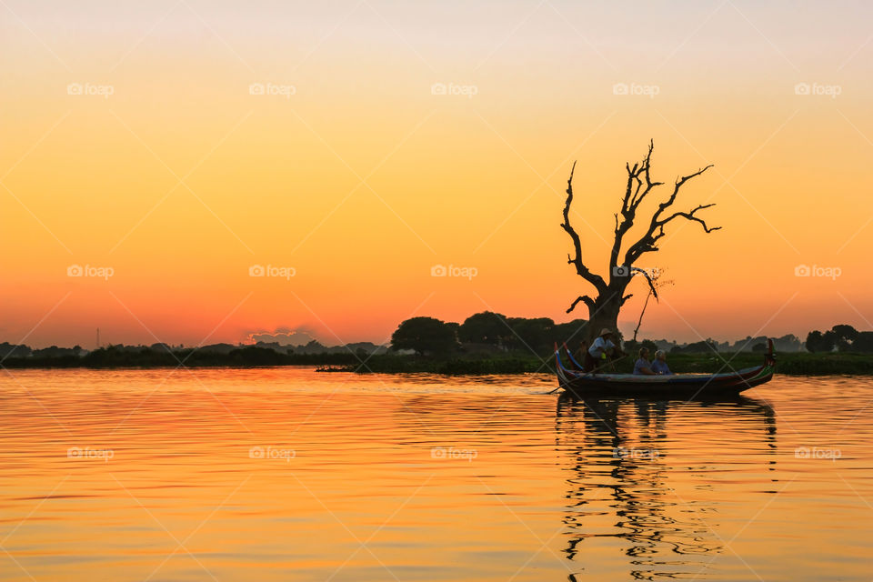 Sunset in Myanmar. Tourists on the boat in lake for sightseeing at sunset golden hour